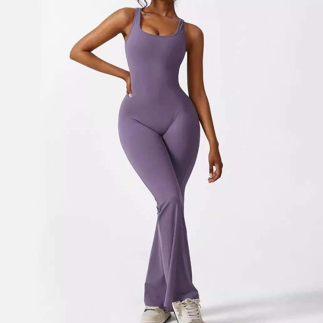 Woman wearing a sleeveless army green flare jumpsuit for yoga, demonstrating the high-elasticity polyester fabric.