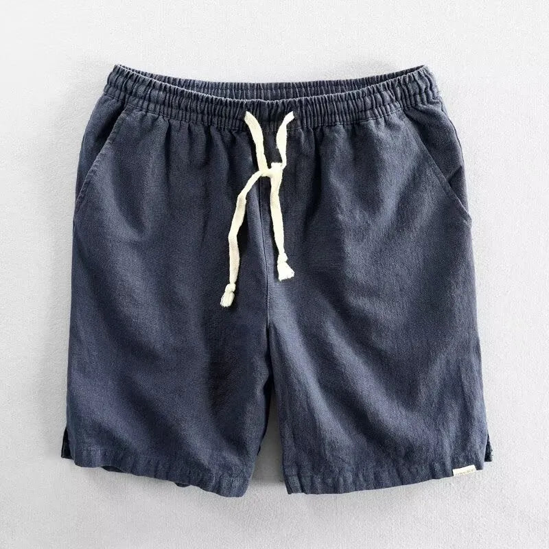 Man wearing loose-fit beige cotton linen casual shorts on a beach