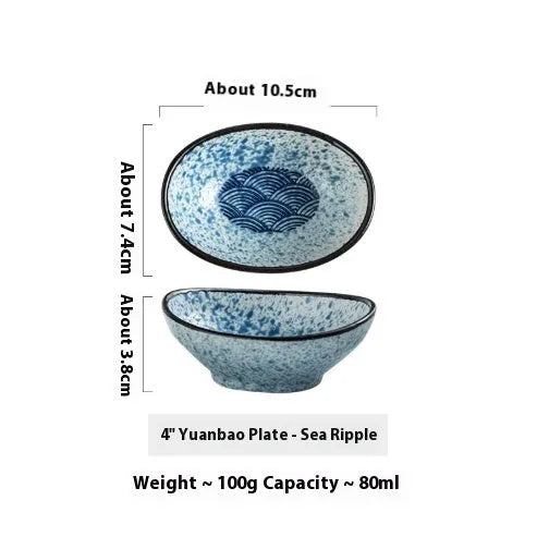 Oval Japanese ceramic sauce dipping bowl with traditional underglaze pattern on a wooden table.