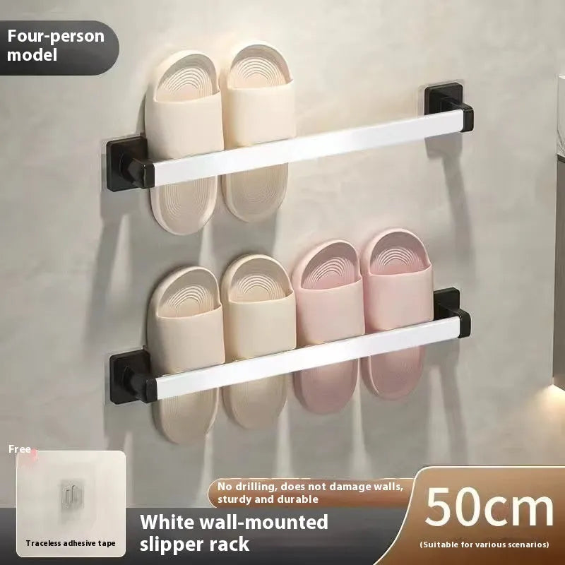 Black wall-mounted bathroom slipper rack with an integrated small seat, shown on a tile wall.