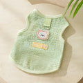 Green knitted cat clothing with a bear patch, showing hollowed-out breathable fabric.