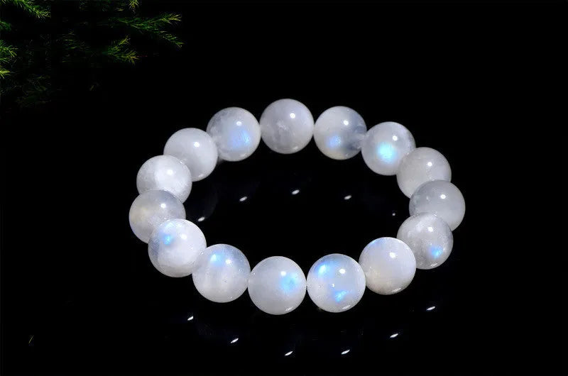 Natural blue moonlight round bead moonstone bracelet on a wrist, showing polished geometric beads.