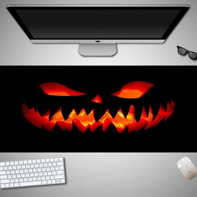 Oversized Halloween-themed gaming mouse pad with non-slip base on a desk.