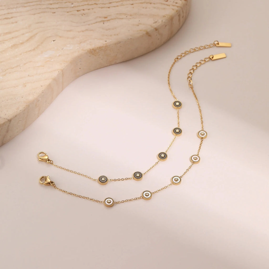 Close-up of a women's geometric fritillary pattern bracelet and necklace set in gold-plated stainless steel.