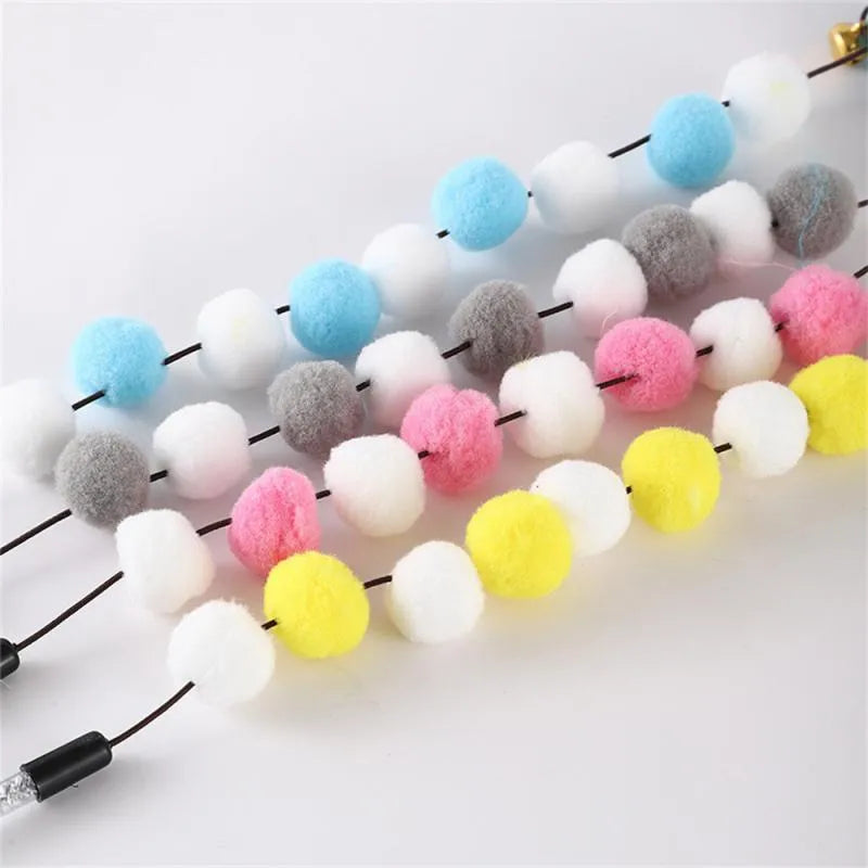 Colourful cat teaser stick with acrylic pompons and feather attachments measuring 31cm long