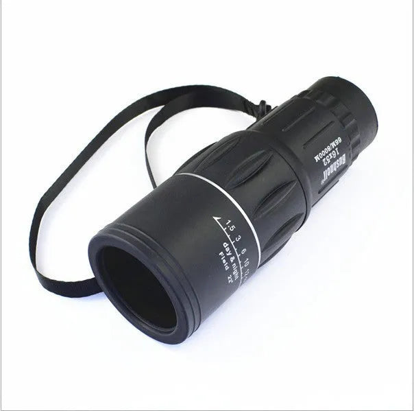 Black 16x52 monocular telescope showing eyepiece and objective lens, placed on a surface.