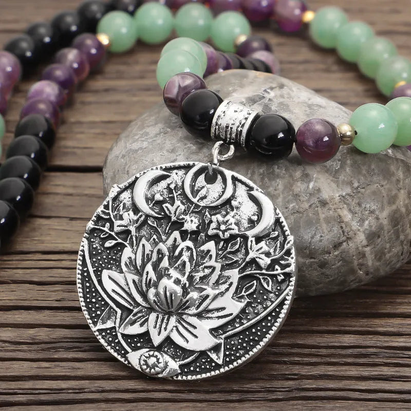 Yoga necklace with geometric lotus pendant and stone bead chain alongside a matching bracelet
