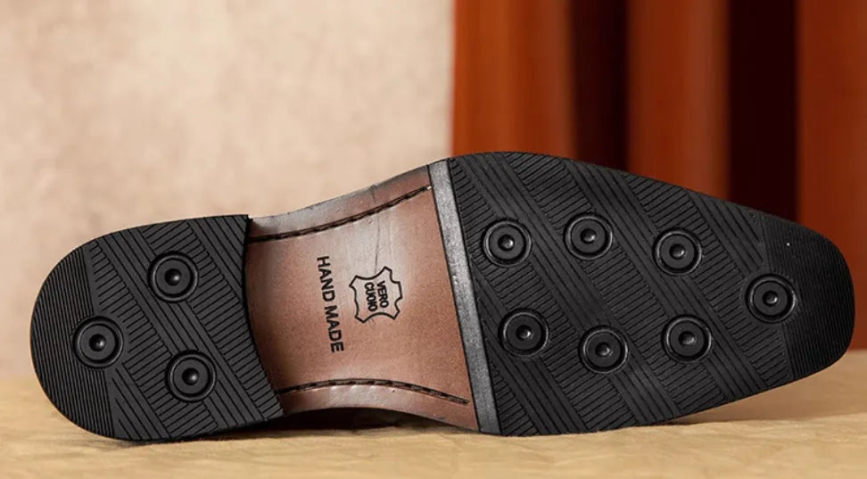 Men's black genuine leather slip-on loafers showing polished finish and rubber sole