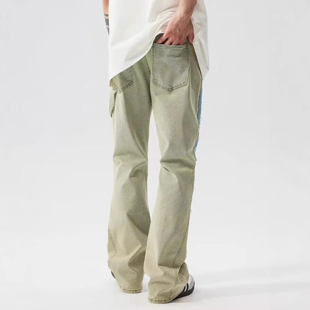 Retro blue and yellow patchwork jeans with splash-ink damaged design on a mid-waist fit.