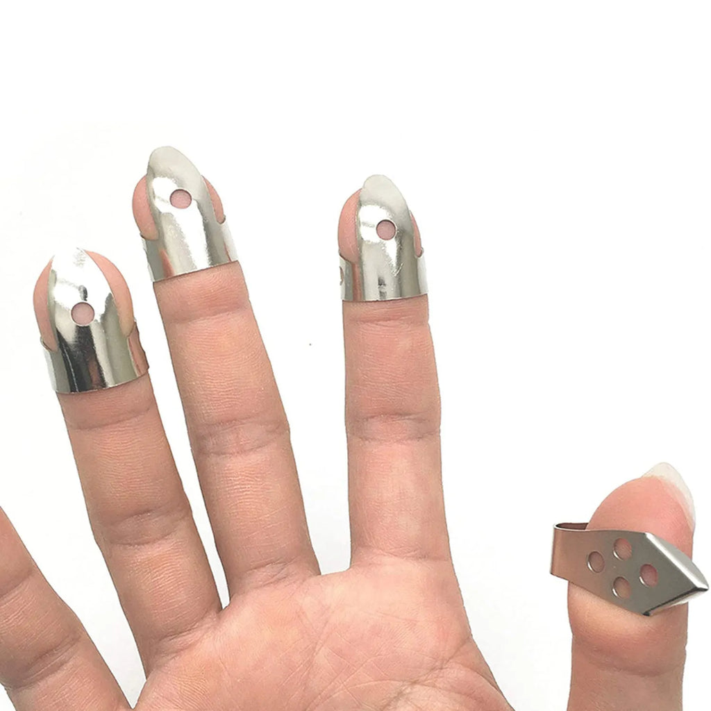 Four silver metal guitar finger stall plectrums laid flat on a surface