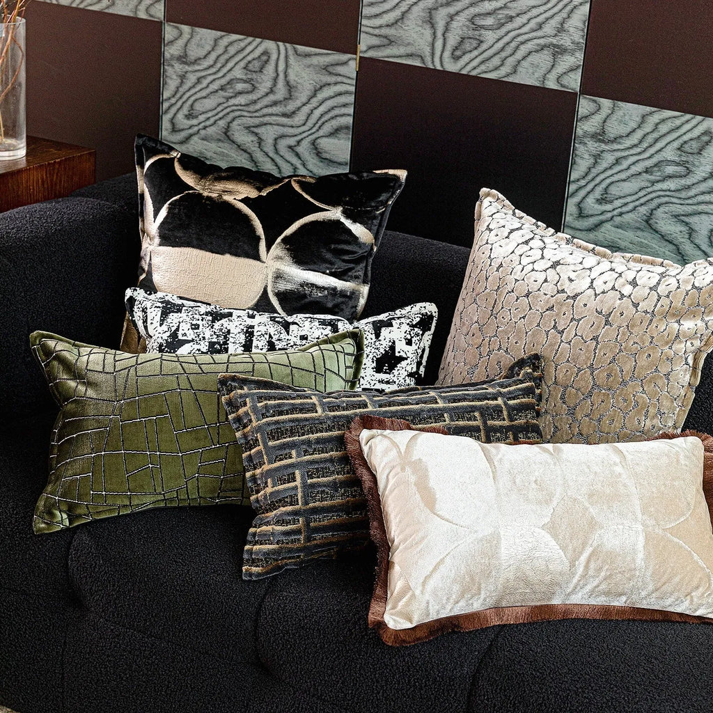 Black and gold abstract print flannel decorative cushion pillow on a sofa.
