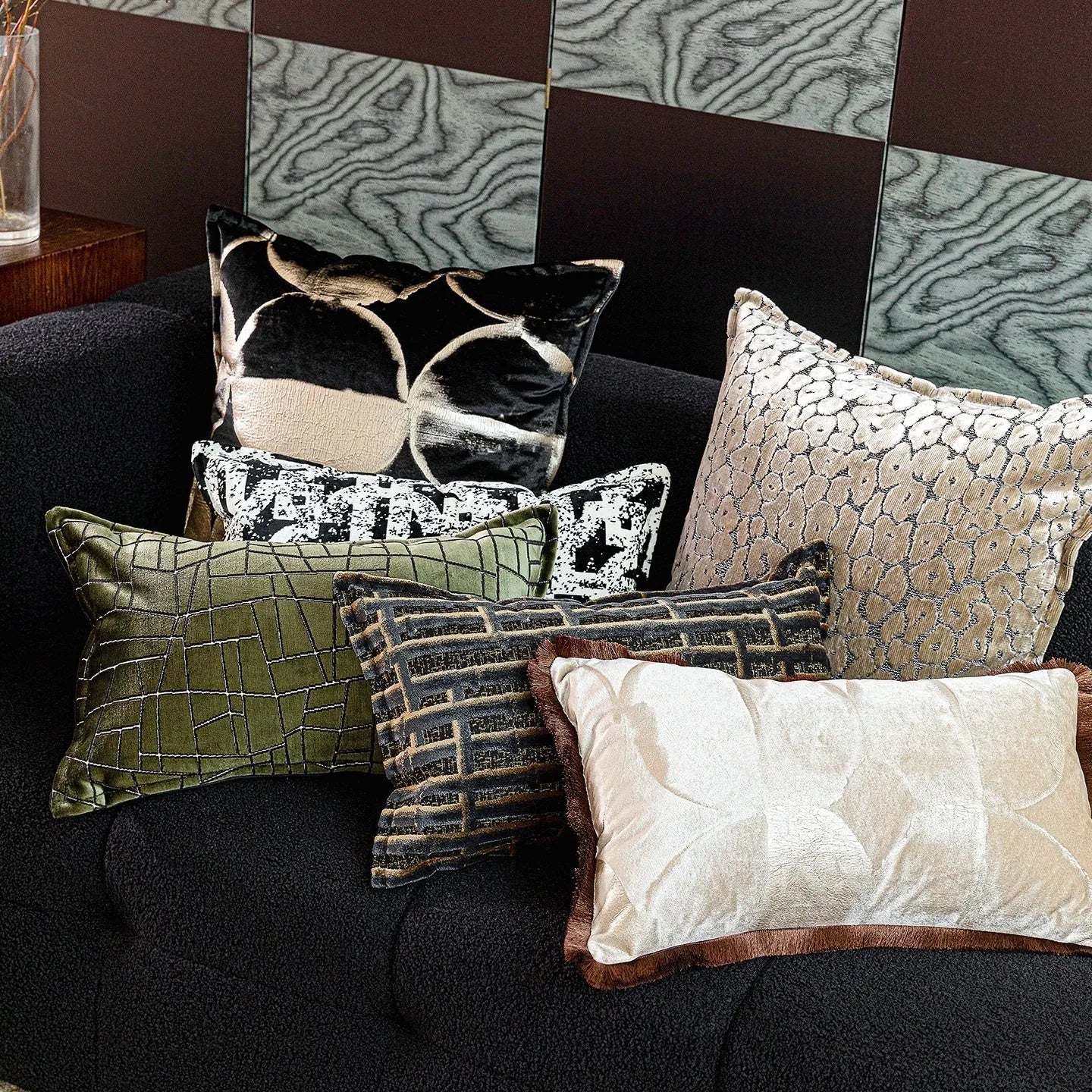 Black and gold abstract print flannel decorative cushion pillow on a sofa.
