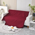 Reversible dog blanket couch cover in grey, laid flat on a sofa