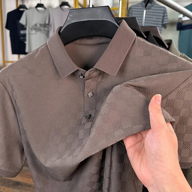 Man wearing a black rhombus patterned short sleeve t-shirt with a side slit detail.