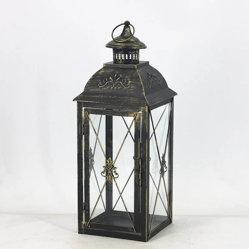Black and white wrought iron floor-standing storm lantern with tempered glass in three sizes for courtyard use.