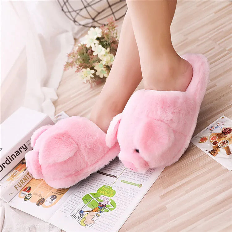 Pink pig-shaped floor slippers with short plush fabric on a plain background.