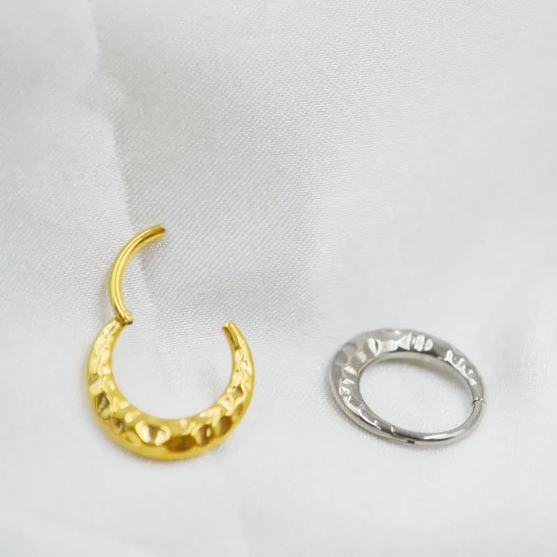 Titanium alloy concave-convex nose ring with carving detail in gold and silver anodised finishes.