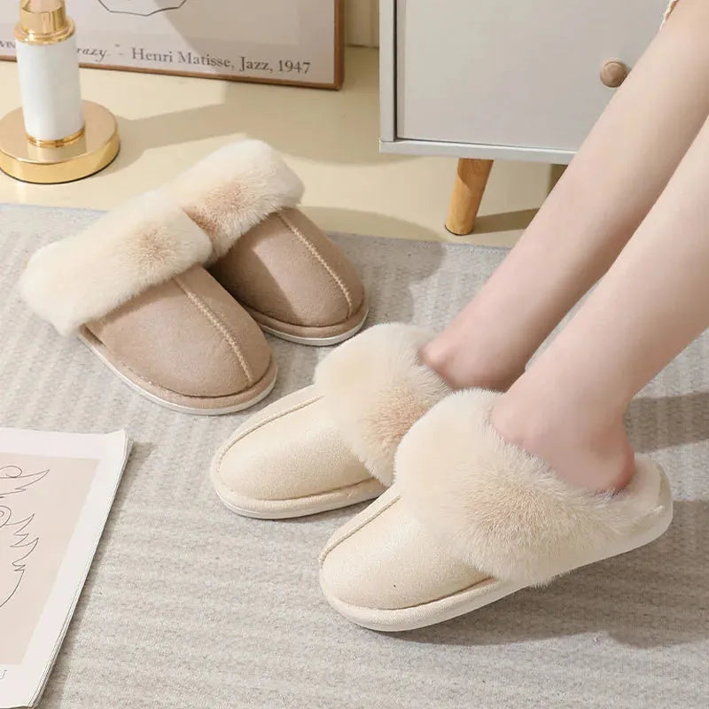 Brown plush indoor slippers with round toe, decorative stitching, and a light-coloured anti-slip sole.