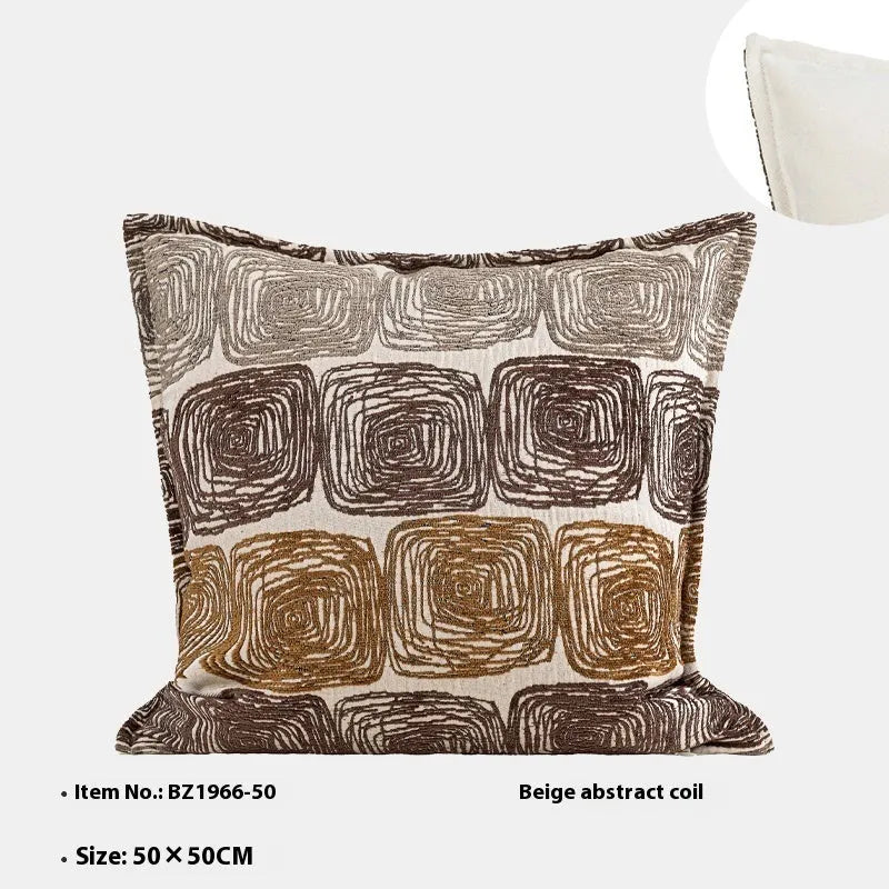 Cream and coffee-coloured abstract coil pattern on two pillow covers: one square, one rectangular.