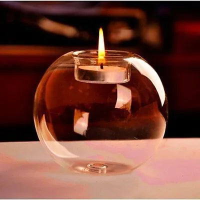 Handmade European hollow glass candle holder in round geometric design on table.