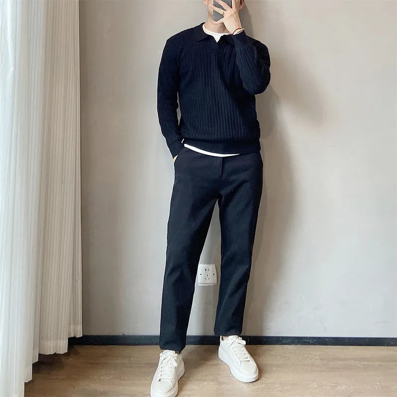 Man wearing a loose black textured knit pullover sweater with long sleeves.