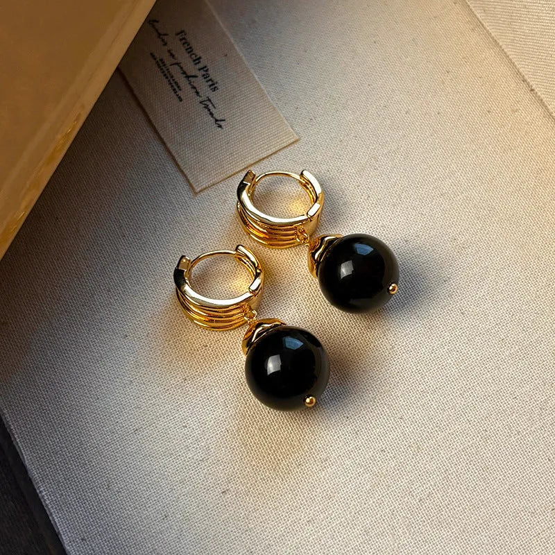 A pair of Fashion Maillard Tigereye earrings with a geometric shape and real gold plating, shown in brown and black colour options.