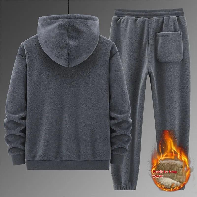 Man wearing a grey hooded cashmere sweater and matching cotton trousers from a casual sports suit.