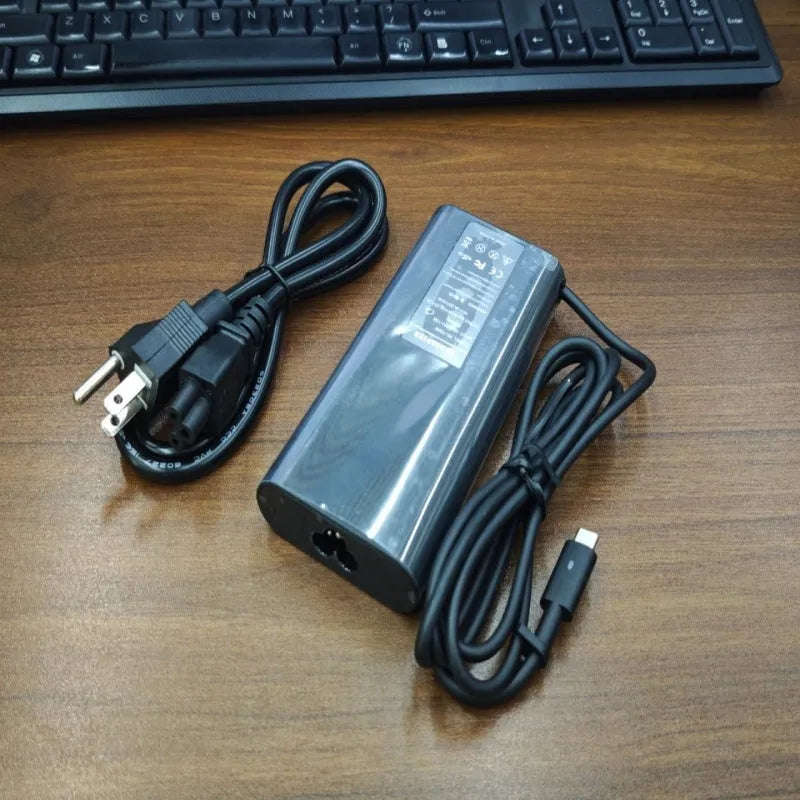 Black 65W Type-C laptop power adapter with six international power cords for worldwide charging