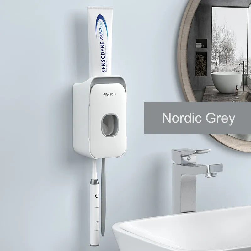 Blue automatic toothpaste dispenser mounted on a bathroom wall with a toothbrush below.