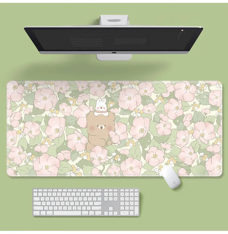 Large floral pattern mouse pad on a desk, showing non-slip rubber base and thin cloth surface.