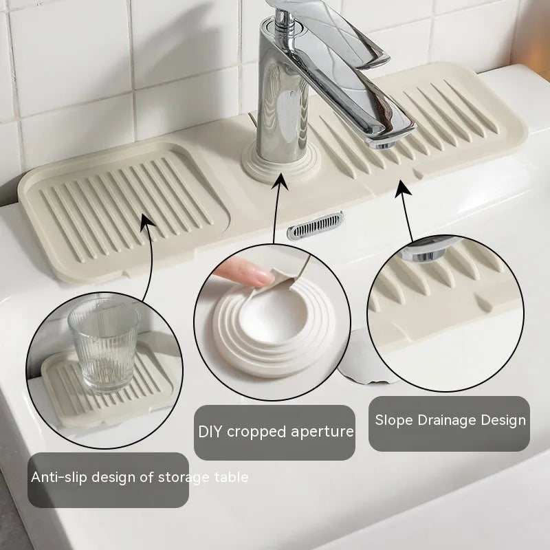 Beige silicone faucet pad with sloped design and drainage channels under a kitchen tap.