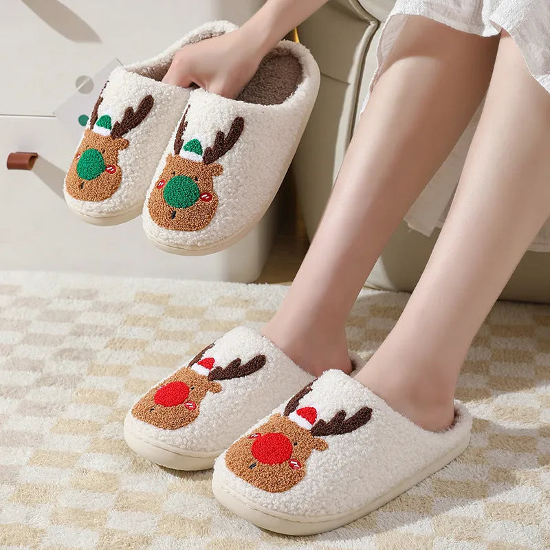 Pair of red Christmas elk plush home slippers on floor, soft anti-slip shoe design