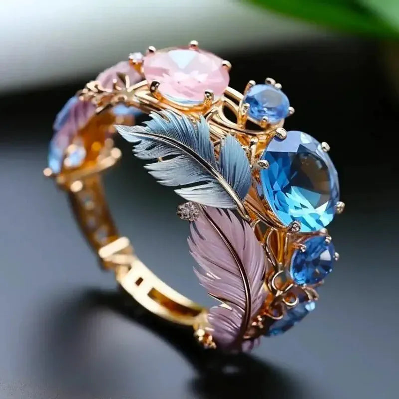 Gold colour brass ring with embossed feather design and cubic zirconia stone.