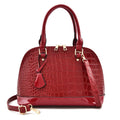 Large shiny black PU leather crossbody bag showing structured shell shape and shoulder strap.