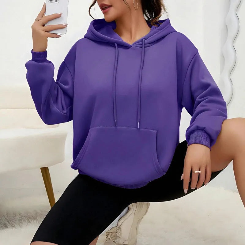 Women's loose grey drawstring hooded sweatshirt with side pockets, on a hanger.