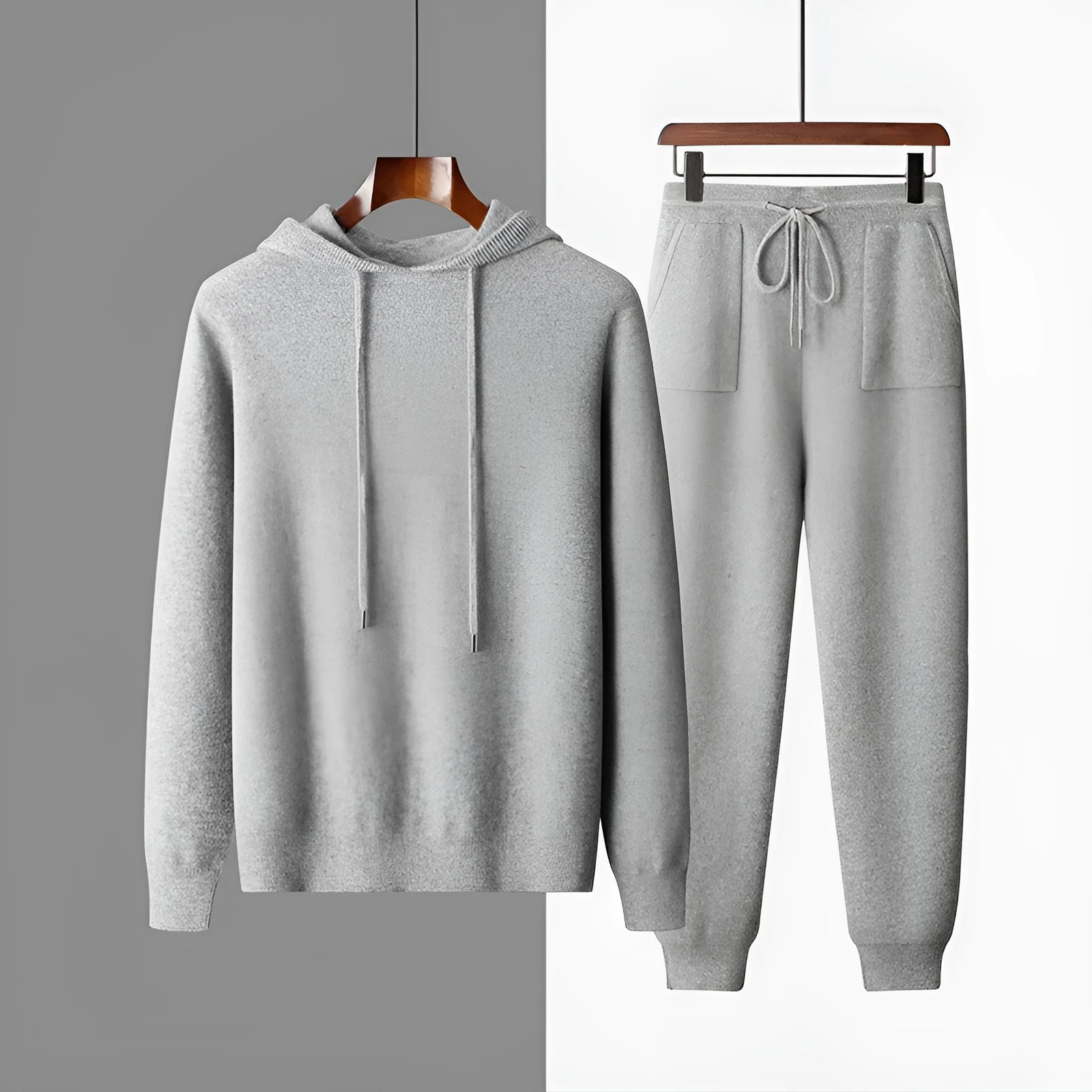 Man wearing a light grey hooded cashmere sweatshirt and matching long pants from a winter leisure set.