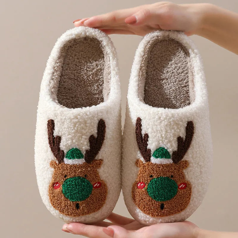 Pair of red Christmas elk plush home slippers on floor, soft anti-slip shoe design