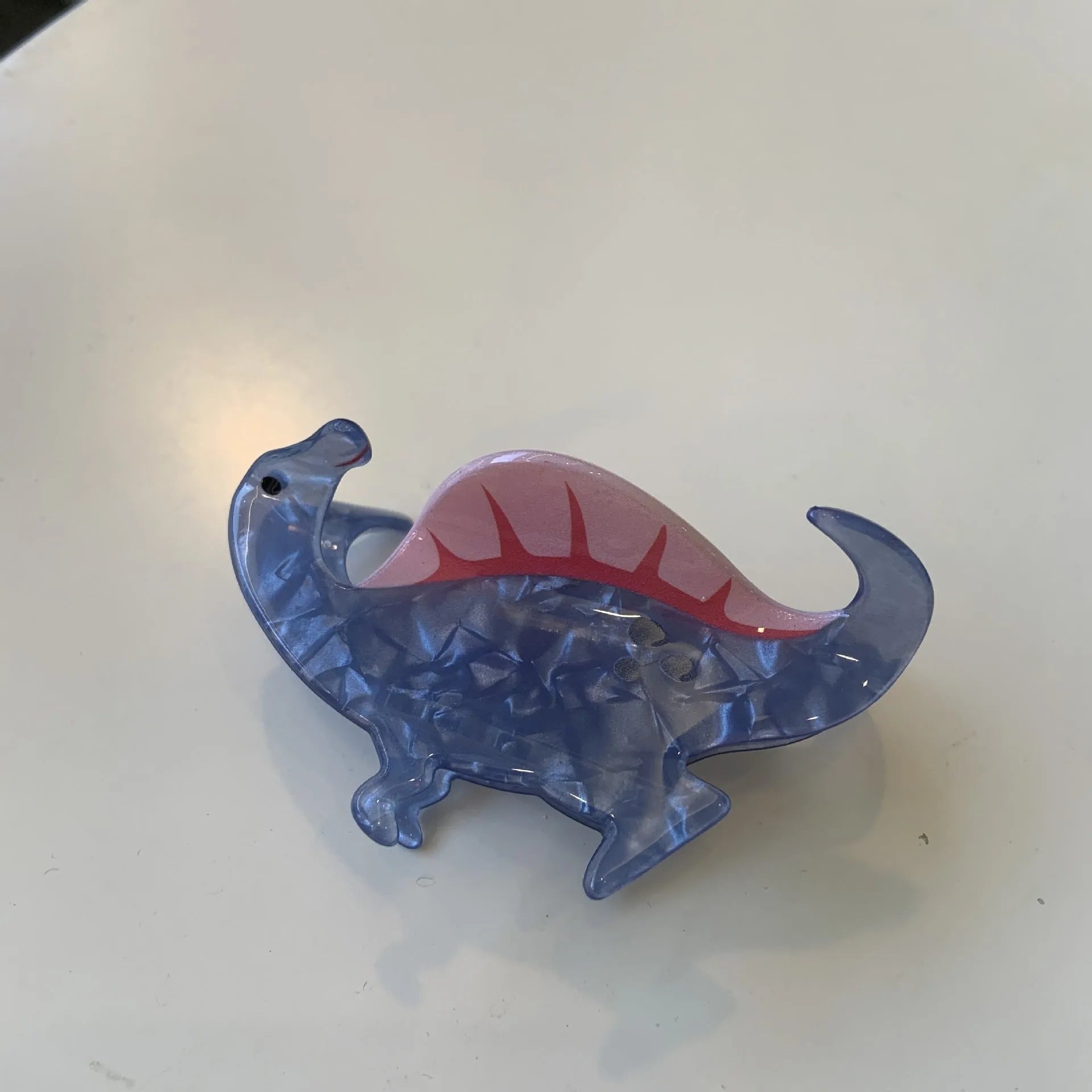 Dinosaur-themed acrylic jaw hair clip showing six colour variations with grip mechanism