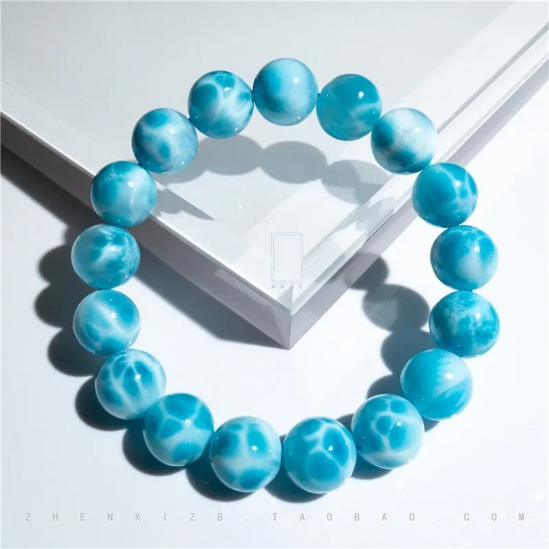 Blue Bodhi bead bracelet with a natural crystal sea-pattern stone charm on a wrist.