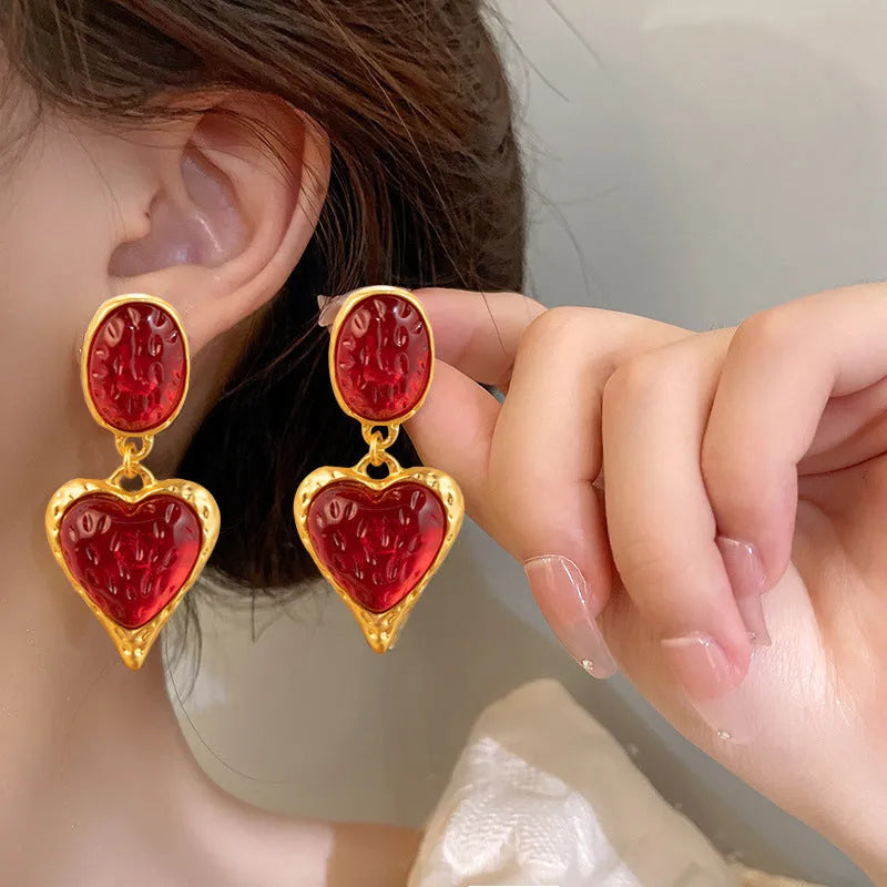 A pair of alloy pleated oval heart-shaped stud earrings with silver posts on a white background.