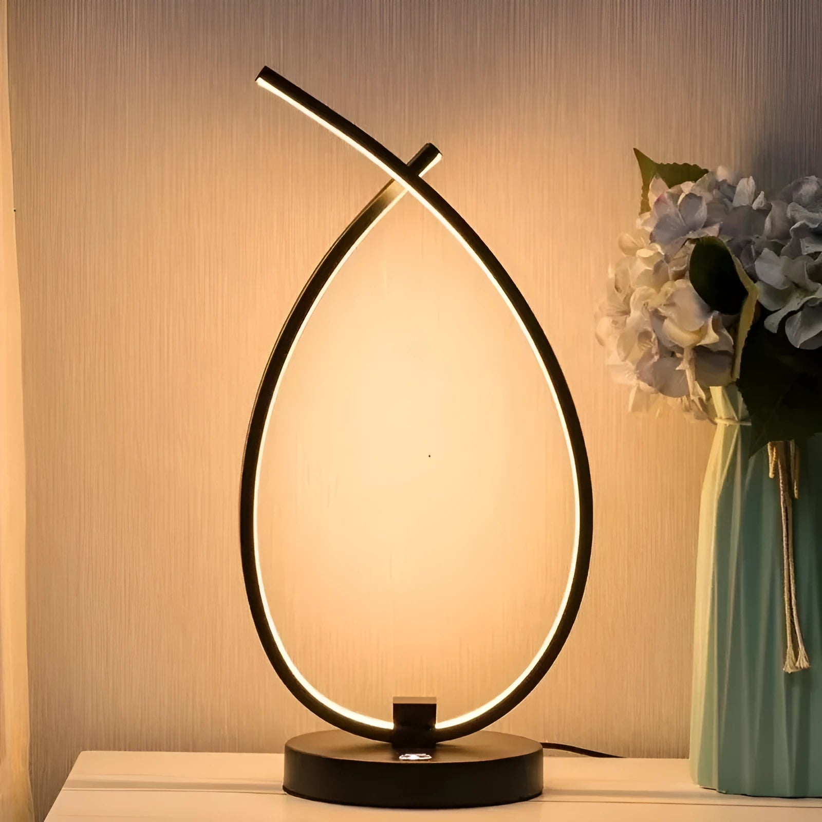 Modern black water drop shaped USB table lamp with touch control on wooden bedside table