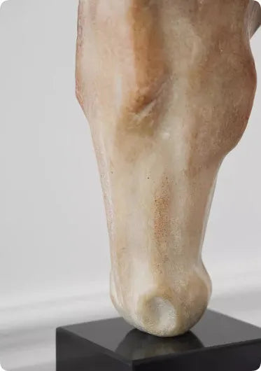 Carved abstract horse head sculpture in retro French style on a desktop.
