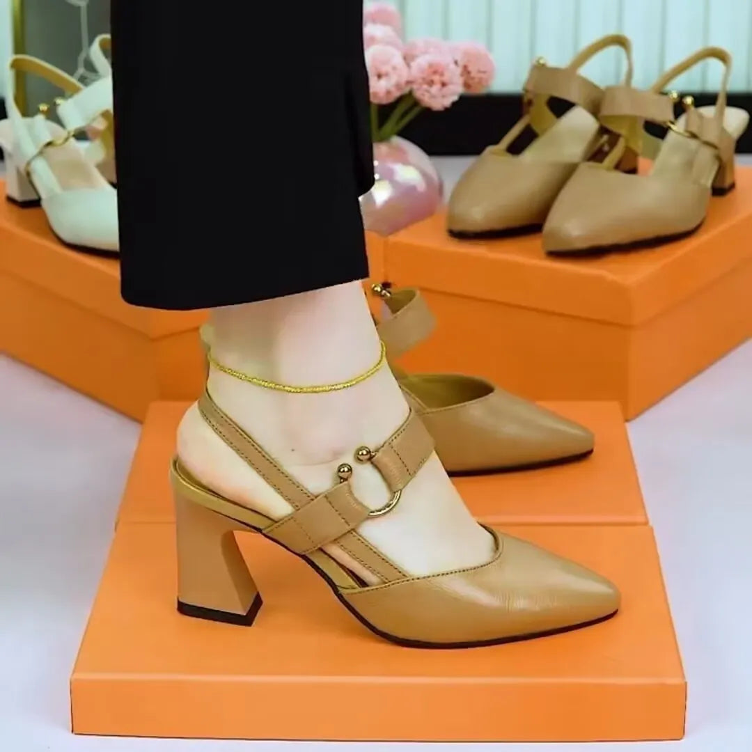 Women's apricot coloured closed toe backless leather sandals with a chunky high heel on a white background.