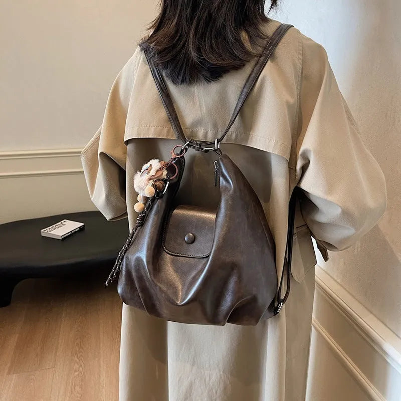 Textured PU leather commuter shoulder backpack in horizontal square shape with single strap and mobile phone compartment
