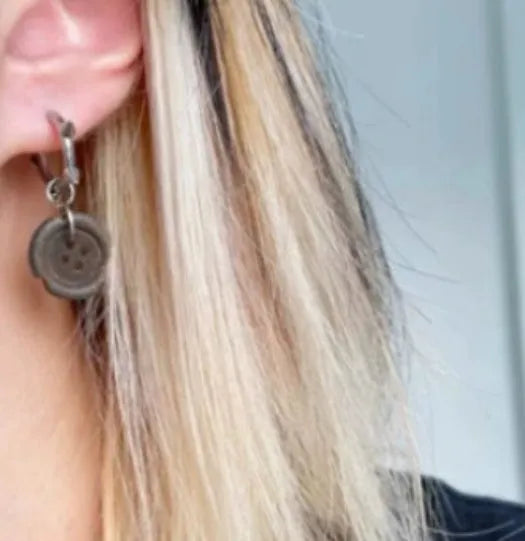 One pair of brown alloy ancient style burned gap button distressed earrings on neutral background