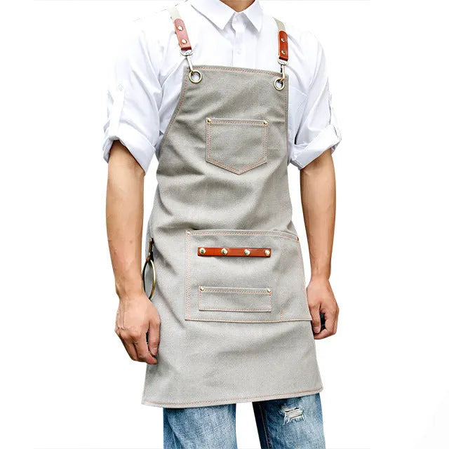 Canvas apron with cross-back straps in camel colour, shown laid flat