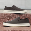 Men's grey slip-on casual shoes with round toe, mid-heel, and visible stitching on a rubber sole.