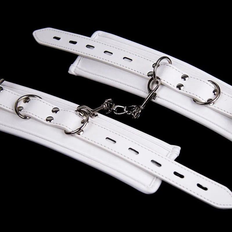 White PU sponge bondage restraint set showing handcuffs, footcuffs, and a neck collar.