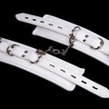 White PU sponge bondage restraint set showing handcuffs, footcuffs, and a neck collar.