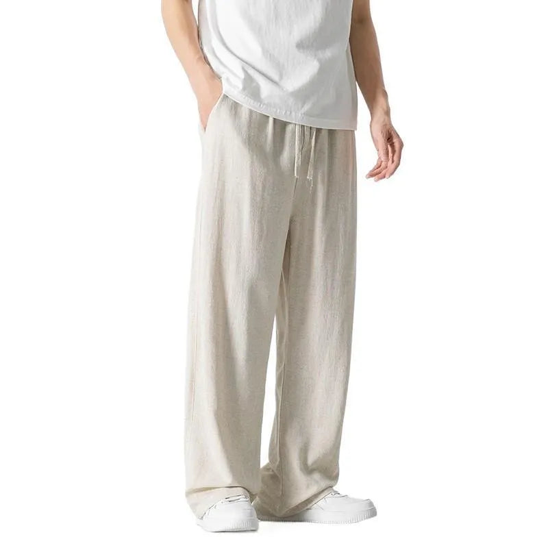 Man modelling beige linen drawstring trousers with a straight-leg cropped fit.